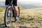 Closeup of cyclist man legs and hands riding mountain bike on outdoor trail in nature