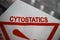 Closeup of cytostatics transportation bag with triangle warning sign, blurred medication pill blisters background