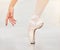 Closeup of dancer foot on floor, ballet shoe and hand, show posture and balance at dance class. Zoom of woman dancing in