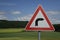 Closeup of a dangerous bend traffic sign in the green countryside of Korborn, Germany