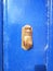 Closeup of Decorative Hand Shaped Knocker on Light Blue Door