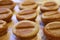 Closeup Delectable Homemade Coffee Bean Shaped Mini Cakes on a Wooden Tray