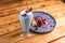 Closeup of a delicious fruity dessert on a plate next to a refreshing milkshake in a restaurant