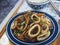 Closeup of delicious juicy Mongolian beef dish on blue plate on wooden tray in a restaurant