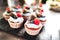 Closeup of delicious miniature cakes. Raspberry, blueberry and blackberry decorated cupcakes. Celebration, party