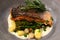 Closeup of a delicious salmon dish with pan-fried samphire, tender stem broccoli and baby spinach