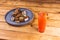 Closeup of delicious saucy chicken wings on a plate next to a refreshing drink on a wooden table