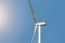 Closeup detail back view of new white modern wind turbine farm power generation station against clear blue sky on day