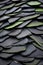 Closeup detail of a roof made of black slate tiles with green tint