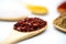 Closeup of the different types of spices with wooden spoons isolated on white background.