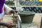 Closeup dirty bucket coated by the wet cement with motion blurred of worker at the construction site