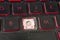 Closeup of a dirty and neglected laptop keyboard with red accents with a missing key. Covered in dust and fine hairs