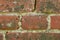 Closeup of a dirty red brick wall with copy space. Weathered exterior surface of a house. Rough surface texture of