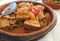 Closeup of dish with traditional spanish andalusian tuna goulash atun encebollado with vegetables on table