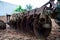 Closeup disk harrows on the back of tractor. Dirty steel blades of tractor