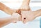 Closeup of diverse group of people making fists in a circle to express unity, support and solidarity. Hands of