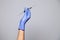 Closeup doctor or nurse hand in rubber latex medical purple glove holding a transparent syringe with sharp needle. Ð¡oncept