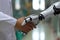 Closeup of a doctor\\\'s hand clasping a robot\\\'s hand. Generative AI