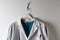 Closeup Doctors White Lab Coat and scrubs on a hanger