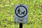 Closeup of dogs allowed small metal white sign with instructions to clean after your dog mounted on wooden pole in local public