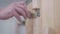 Closeup of door of cedar phytobarrel. Hand of master uses metal lock on latches