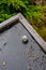 Closeup of downspout filter on a flat carport roof, after storm debris has been cleared and rainwater flooding released from roof