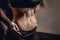 Closeup of drop of sweat on skin abdomen woman after workout. Dark background