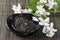 Closeup of dry green tea and jasmine flowers on the black saucer, green bamboo serving mat