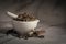 Closeup of Dry Punarnava roots and leaves, in white ceramic mortar and pestle.