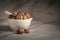 Closeup of Dry Tubers of Amarkand fruits, in white ceramic mortar and pestle.