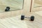 Closeup dumbell on the floor in fitness club with mirror reflection, fitness concept