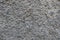 Closeup of dusty wall with coarse gray roughcast finish