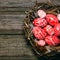 Closeup Easter red eggs with folk white pattern inside bird nest on rustic wood board. Top view