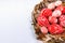 Closeup Easter red eggs with folk white pattern inside bird nest on white background. Top view