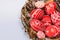 Closeup Easter red eggs with folk white pattern inside bird nest on white background. Top view. Ukrainian traditional eggs