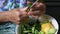 Closeup elder hands peeling cucumber peels with kitchen knife