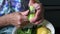 Closeup elderly 80s woman hands cut cucumber peels with knife