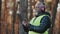 Closeup elderly forestry engineer enters data into logging tablet reforestation of woodland serious professional worker