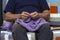 Closeup of elderly man knitting a purple sweater. Knitting like hobbies handmade