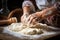 closeup of an elderly woman\\\'s hands covered with flour kneading dough on the table