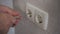 Closeup of electrician hands with screwdriver unscrew outlet