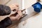 Closeup of an electrician\'s hand repairing an electrical outlet in the wall. Hazardous concept, high voltage, risk, wiring