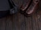 Closeup of elegant stylish brown male boots with shoes box on wooden background.