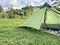 Closeup of an empty tent in a green meadow.