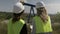 Closeup of engineers supervisors women with helmet examining oil pump platform rig extracting activity with tablet -