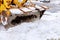 Closeup of excavator for snow removal on a snowy parking lot covered after blizzard