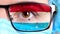 Closeup, eye, part of doctor face in medical mask, glasses, which painted in colors of Luxembourg flag. Many viruses