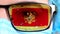 Closeup, eye, part of doctor face in medical mask, glasses, which painted in colors of Montenegro flag. Many viruses