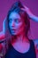 Closeup face of beautiful brunete woman in neon light red and blue