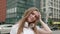 Closeup face of beautiful smiling woman with long hair outdoors. Portrait of millenial female with headphones looking to